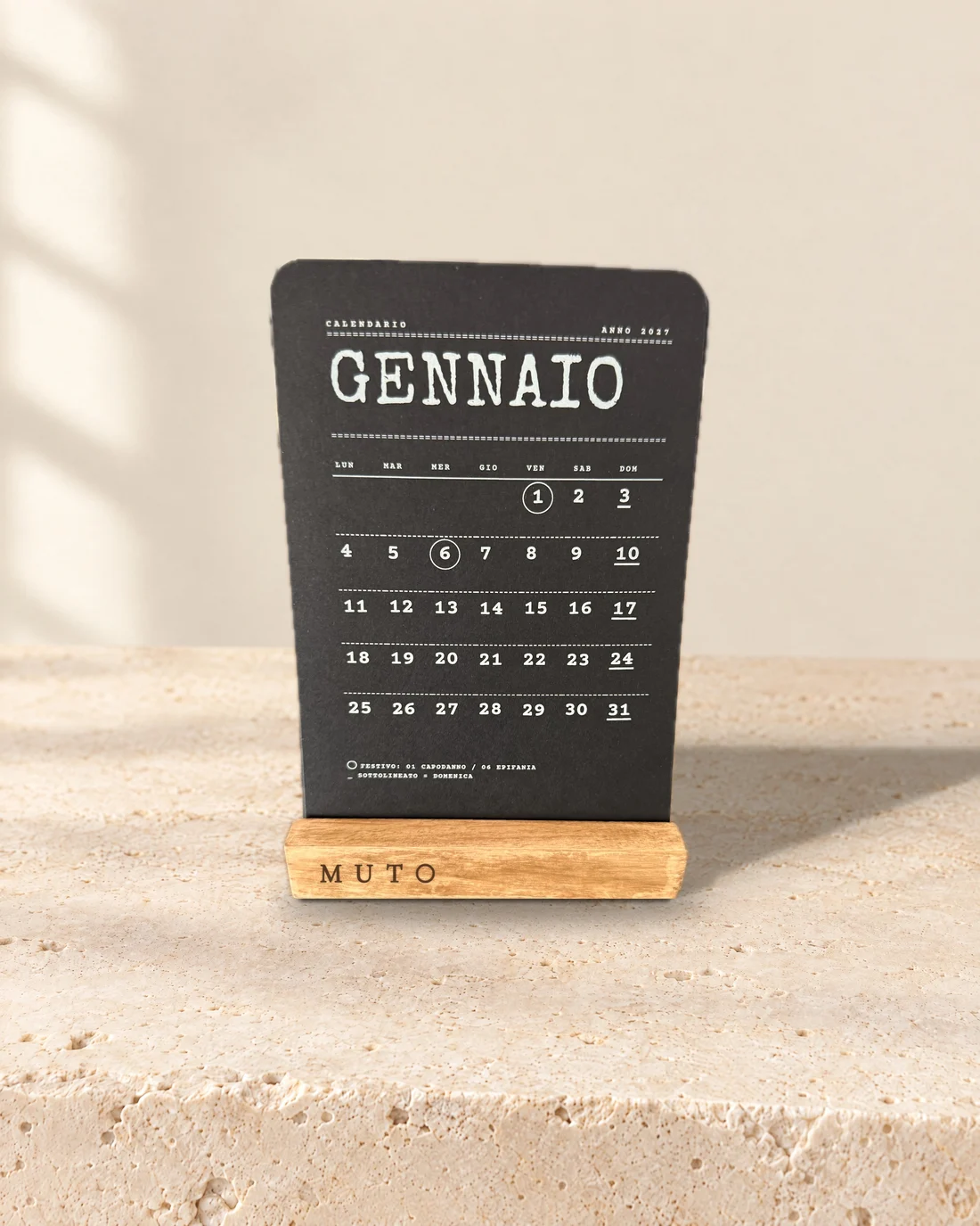 Calendario Essenziale: base in legno con MUTO inciso e il cartoncino nero di gennaio, grafica Dattilo